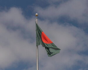 The national flag of Bangladesh against a blue sky.