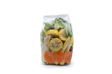 Carrots, vegetables, corn, and golden needle mushrooms are ready for sale in transparence plastic bags on white background. Clipping Path.