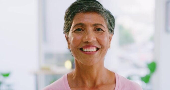 Closeup portrait of the face and head of one senior mixed race woman with a beautiful smile standing inside. Happy with her dental hygiene, and confident in the health of her mouth, teeth and gums