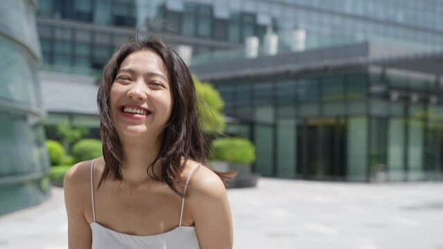 Charming young asian woman looking at camera smile in the summer city slow motion say love you cute girlfriend