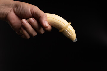 condom, hand hold banana with condom, sex education concept.