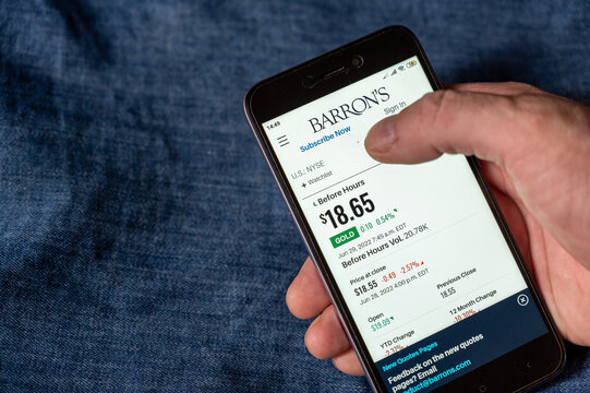 Webpage of Barron's Financial Weekly. A mature man's hand holds a smartphone. World gold price quotes on the screen of the device. Ukraine, Mykolaiv - 06 29 2022
