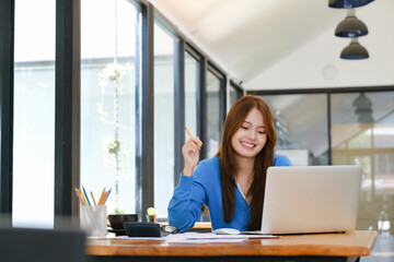 A female college student uses a computer to access the Internet for online learning..