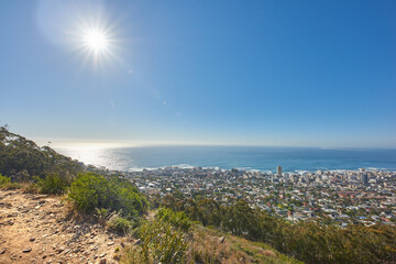 Copy space with views from Table Mountain in Cape Town South Africa of a clear blue sky over a coastal city. Scenic landscape of buildings in an urban town along the mountain and sea on a sunny day