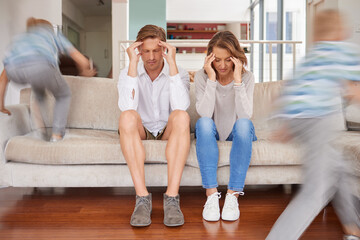 Naughty hyperactive, energetic children annoying their mother and father at home. Tired and...