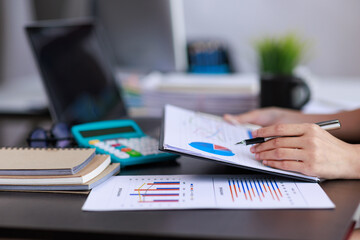 Financial Businesswomen analyze the graph of the company's performance to create profits and...