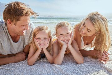 Portrait of a carefree family relaxing and bonding on the beach. Two cheerful little girls spending...