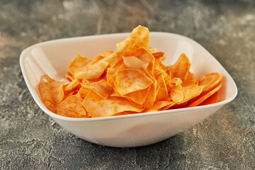 Sweet potato chips in white plate are ready to be eaten