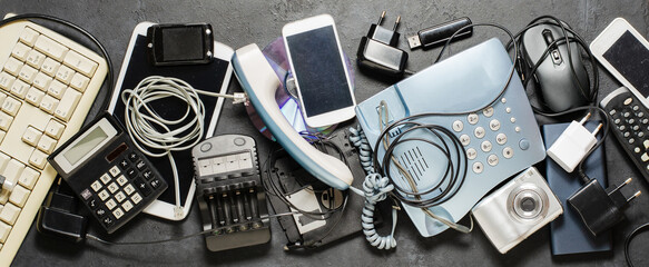 Old electronic devices on a dark background. The concept of recycling and disposal of electronic...