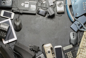 Old electronic devices on a dark background. The concept of recycling and disposal of electronic...