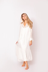 Portrait of a beautiful and young adult model of a blonde woman in a white dress on a white background. Studio shot.