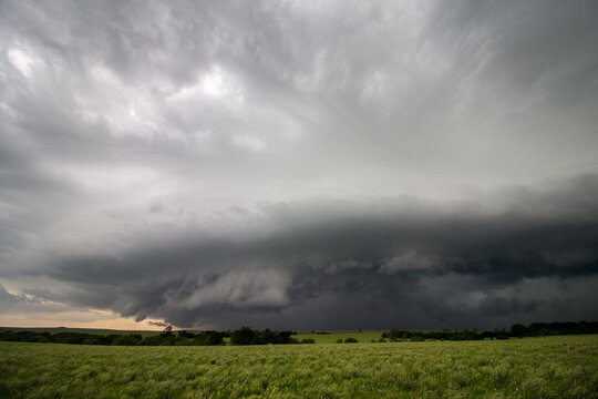 A severe thunderstorm with a shelf cloud over a green field in Kansas.