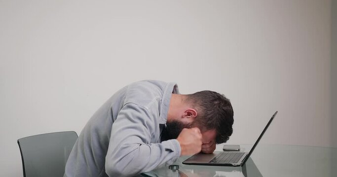 Man types on keyboard feeling irritated of laptop lagging