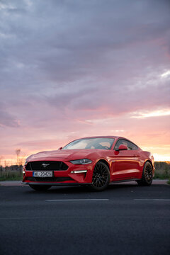 Nysa, Poland - October 13, 2019: Amazing colorful sky over red sports car Ford Mustang
