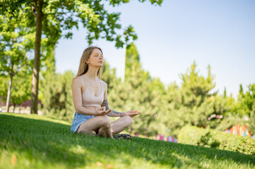 Naklejka na ściany i meble Girl practice yoga meditation outdoor in park
