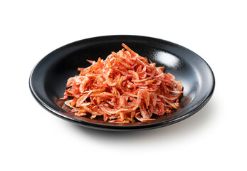 Dried sakura shrimps on a plate placed on a white background.