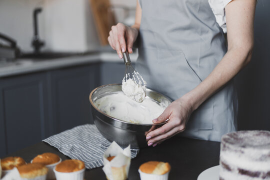 Young lovely woman pastry chef preparing cake cream at home