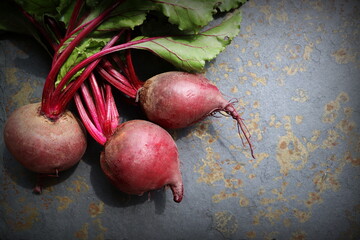 Fresh beetroot with leaves on a grey stone background. Healthy food. Top view. Free space for your text