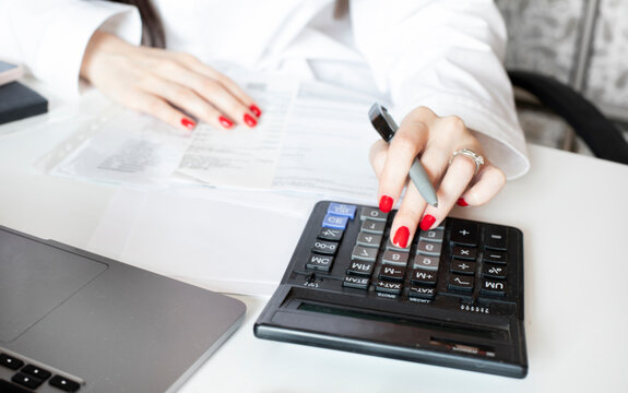 Mortgage house credit accountant consulting woman calculating risks. Money female manager portrait photo with laptop, pen, making marks. View from behind