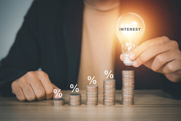 businessman holding a bright light bulb With money and percentage page, white percentage interest rate concept. Productivity. Increase sales. Business growth. Trading performance with growth rate