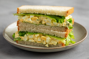 Homemade Egg Salad Sandwich with Lettuce on a Plate, side view.