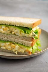 Homemade Egg Salad Sandwich with Lettuce on a Plate, side view.