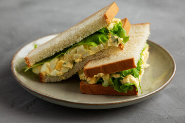 Homemade Egg Salad Sandwich with Lettuce on a Plate, side view.