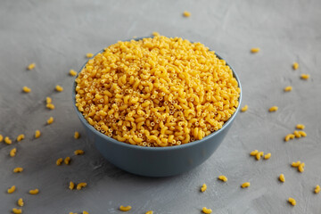 Dry Organic Pasta Coquillettes in a Bowl, side view.