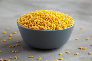 Dry Organic Pasta Coquillettes in a Bowl, side view.