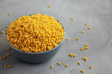Dry Organic Pasta Coquillettes in a Bowl, side view.