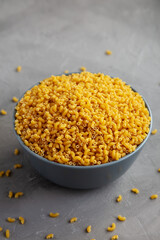 Dry Organic Pasta Coquillettes in a Bowl, side view.