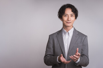 笑顔で話をしている日本人男性/スーツを着ている