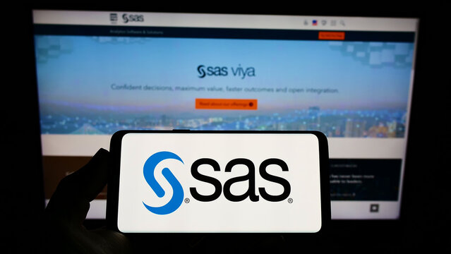Stuttgart, Germany - 01-29-2022: Person holding smartphone with logo of US analytics software company SAS Institute Inc. on screen in front of website. Focus on phone display.