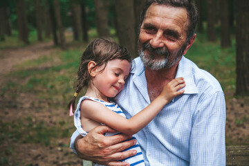 Senior man holding his little granddaughter