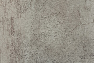 Painted old cement wall, light beige abstract background. A cracked concrete wall texture with scratches.