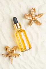 Yellow oil serum essence in glass bottle flatlay. Sunscreen oil to protect the face and body from...