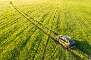 Aerial view of Renault Duster car SUV driving on countryside road in spring field rural landscape....