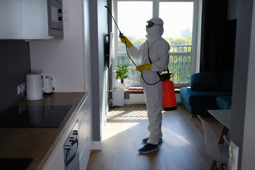 Worker in protective suit cleans room from cockroaches and rats with spray gun - obrazy, fototapety, plakaty