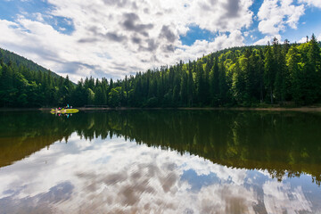 landscape with calm lake in summer. tranquil nature with forest reflection in the water. beautiful travel background of synevyr, ukraine. green outdoor environment