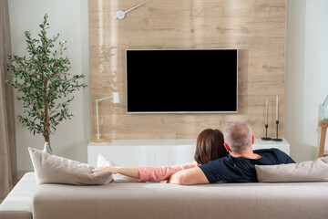 adult couple in modern living room in front of tv