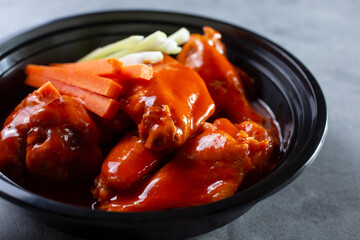 A closeup view of a bowl of buffalo wings.