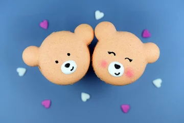 Foto op Canvas Cute macarons in a shape of bears, blue background, small hearts around. Love concept © Martina