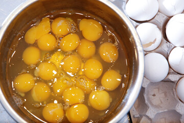 A top down view of a large bowl of raw eggs.