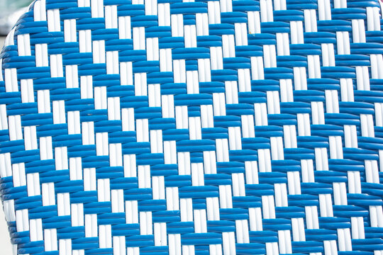 A closeup view of a blue and white wicker weave design, as a background.