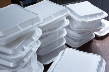 A view of stacks of styrofoam takeout boxes, in a restaurant setting.