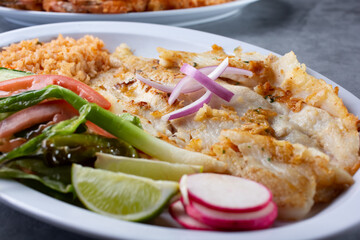 A view of a plate of deep fried tilapia filet.