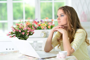 Portrait of  young  thoughtful woman working with laptop