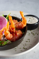 A view of a plate of bacon-wrapped shrimp.