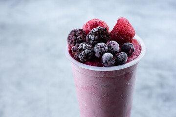 A view of a fruit smoothie featuring frozen berries.