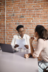 Black human resource manager talks to job candidate on meeting in office.